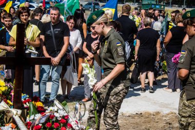 Lviv, Ukrayna, 29 Ağustos 2024 Mars meydanında, bir askeri mezarlık, askerler, silah arkadaşları, Rus ordusuna karşı savaşta ölen kendilerinden birinin mezarının önünde toplandı..