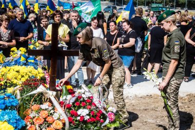 Lviv, Ukrayna, 29 Ağustos 2024 Mars meydanında, bir askeri mezarlık, askerler, silah arkadaşları, Rus ordusuna karşı savaşta ölen kendilerinden birinin mezarının önünde toplandı..