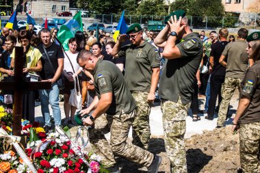 Lviv, Ukrayna, 29 Ağustos 2024 Mars meydanında, bir askeri mezarlık, askerler, silah arkadaşları, Rus ordusuna karşı savaşta ölen kendilerinden birinin mezarının önünde toplandı..