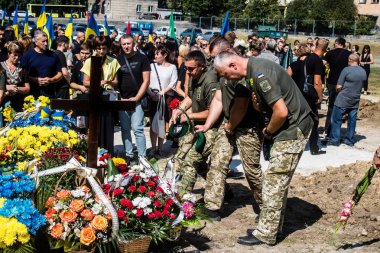 Lviv, Ukrayna, 29 Ağustos 2024 Mars meydanında, bir askeri mezarlık, askerler, silah arkadaşları, Rus ordusuna karşı savaşta ölen kendilerinden birinin mezarının önünde toplandı..