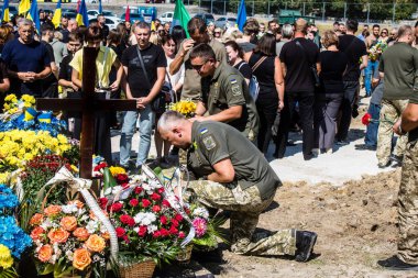 Lviv, Ukrayna, 29 Ağustos 2024 Mars meydanında, bir askeri mezarlık, askerler, silah arkadaşları, Rus ordusuna karşı savaşta ölen kendilerinden birinin mezarının önünde toplandı..