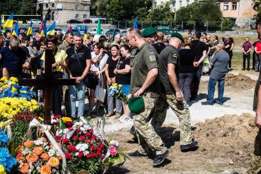 Lviv, Ukrayna, 29 Ağustos 2024 Mars meydanında, bir askeri mezarlık, askerler, silah arkadaşları, Rus ordusuna karşı savaşta ölen kendilerinden birinin mezarının önünde toplandı..