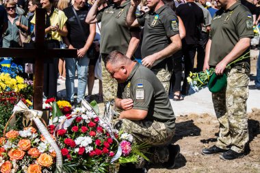 Lviv, Ukrayna, 29 Ağustos 2024 Mars meydanında, bir askeri mezarlık, askerler, silah arkadaşları, Rus ordusuna karşı savaşta ölen kendilerinden birinin mezarının önünde toplandı..
