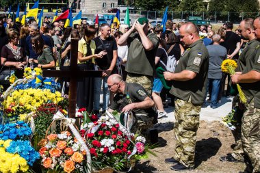 Lviv, Ukrayna, 29 Ağustos 2024 Mars meydanında, bir askeri mezarlık, askerler, silah arkadaşları, Rus ordusuna karşı savaşta ölen kendilerinden birinin mezarının önünde toplandı..