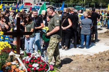 Lviv, Ukrayna, 29 Ağustos 2024 Mars meydanında, bir askeri mezarlık, askerler, silah arkadaşları, Rus ordusuna karşı savaşta ölen kendilerinden birinin mezarının önünde toplandı..