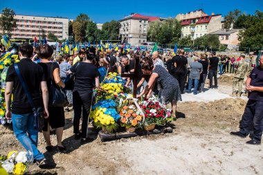 Lviv, Ukrayna, 29 Ağustos 2024 Mars 'taki Lviv askeri mezarlığındaki aile ve arkadaşları Rus ordusuyla savaşta ölen iki Ukraynalı askerin defnedilmesine katıldılar..