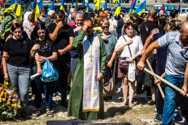 Lviv, Ukrayna, 29 Ağustos 2024 Mars 'taki Lviv askeri mezarlığındaki aile ve arkadaşları Rus ordusuyla savaşta ölen iki Ukraynalı askerin defnedilmesine katıldılar..