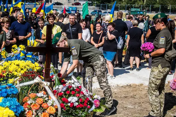 Lviv, Ukrayna, 29 Ağustos 2024 Mars meydanında, bir askeri mezarlık, askerler, silah arkadaşları, Rus ordusuna karşı savaşta ölen kendilerinden birinin mezarının önünde toplandı..