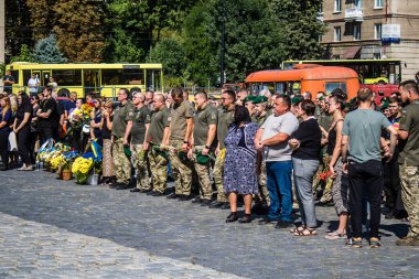 Lviv, Ukrayna, 29 Ağustos 2024 Mars 'taki Lviv askeri mezarlığındaki aile ve arkadaşları Rus ordusuyla savaşta ölen iki Ukraynalı askerin defnedilmesine katıldılar..