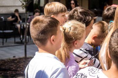 Lviv, Ukrayna, 29 Ağustos 2024. Çocuklar, Ukrayna ordusuna gidecek bir aracı finanse etmek için Lviv şehir merkezindeki bir yardım gecesine katılıyor..