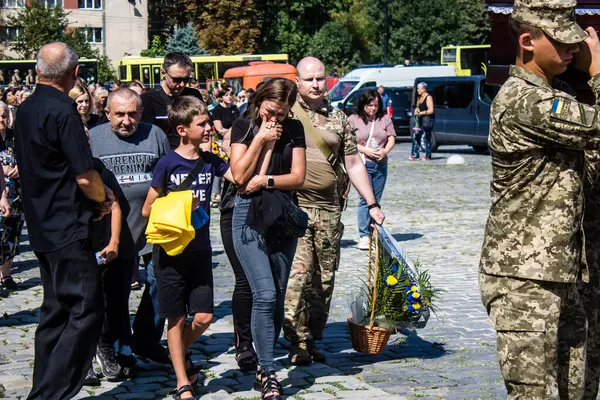 Lviv, Ukrayna, 29 Ağustos 2024 Mars 'taki Lviv askeri mezarlığındaki aile ve arkadaşları Rus ordusuyla savaşta ölen iki Ukraynalı askerin defnedilmesine katıldılar..