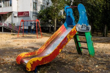 Kharkiv, Ukrayna, 12 Eylül 2024 Saltivka bölgesindeki hasarlı bir binanın önündeki terk edilmiş çocuk parkı. Büyük çaplı Rus füzeleri saldırısından sonra çocuklar buradan tahliye edildi..