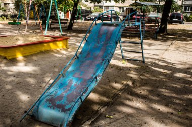 Kharkiv, Ukrayna, 12 Eylül 2024 Saltivka bölgesindeki hasarlı bir binanın önündeki terk edilmiş çocuk parkı. Büyük çaplı Rus füzeleri saldırısından sonra çocuklar buradan tahliye edildi..