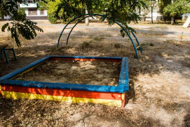 Kharkiv, Ukrayna, 12 Eylül 2024 Saltivka bölgesindeki hasarlı bir binanın önündeki terk edilmiş çocuk parkı. Büyük çaplı Rus füzeleri saldırısından sonra çocuklar buradan tahliye edildi..