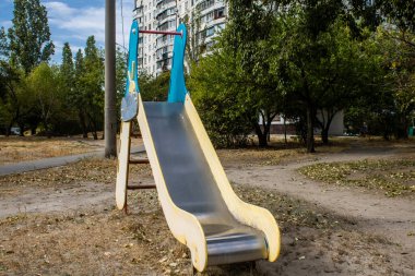 Kharkiv, Ukrayna, 12 Eylül 2024 Saltivka bölgesindeki hasarlı bir binanın önündeki terk edilmiş çocuk parkı. Büyük çaplı Rus füzeleri saldırısından sonra çocuklar buradan tahliye edildi..