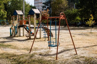 Kharkiv, Ukrayna, 12 Eylül 2024 Saltivka bölgesindeki hasarlı bir binanın önündeki terk edilmiş çocuk parkı. Büyük çaplı Rus füzeleri saldırısından sonra çocuklar buradan tahliye edildi..
