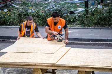 Kharkiv, Ukrayna, 16 Eylül 2024. Rus saldırısından sonra binayı temizleyip onarıyor. Patlama, cam ve metal parçalarını her yöne uçurdu ve ciddi hasara yol açtı..