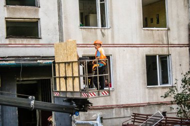 Kharkiv, Ukrayna, 16 Eylül 2024. Rus saldırısından sonra binayı temizleyip onarıyor. Patlama, cam ve metal parçalarını her yöne uçurdu ve ciddi hasara yol açtı..