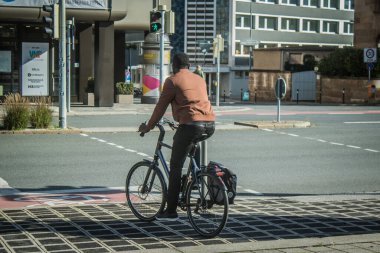 Nuremberg, Almanya, 10 Ekim 2024. Nuremberg 'den bir Alman vatandaşı bisikletini şehir merkezinde sürüyor. Bir ulaşım aracı olarak bisiklet Almanya 'da çok popülerdir..