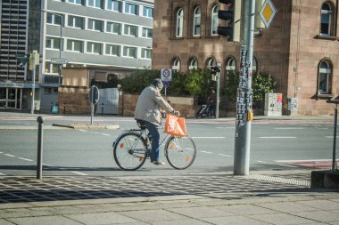 Nuremberg, Almanya, 10 Ekim 2024. Nuremberg 'den bir Alman vatandaşı bisikletini şehir merkezinde sürüyor. Bir ulaşım aracı olarak bisiklet Almanya 'da çok popülerdir..