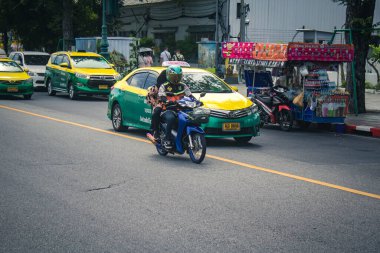 Bangkok, Tayland, 25 Kasım 2024 Tayland 'ın başkenti Bangkok sokaklarında motosikletle gezen insanlar, hayat dolu sokak hayatlarıyla tanınıyorlar..