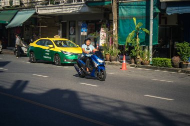 Bangkok, Tayland, 25 Kasım 2024 Tayland 'ın başkenti Bangkok sokaklarında motosikletle gezen insanlar, hayat dolu sokak hayatlarıyla tanınıyorlar..
