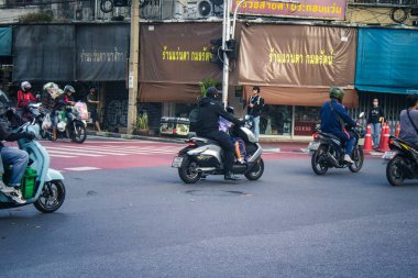 Bangkok, Tayland, 25 Kasım 2024 Tayland 'ın başkenti Bangkok sokaklarında motosikletle gezen insanlar, hayat dolu sokak hayatlarıyla tanınıyorlar..