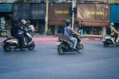Bangkok, Tayland, 25 Kasım 2024 Tayland 'ın başkenti Bangkok sokaklarında motosikletle gezen insanlar, hayat dolu sokak hayatlarıyla tanınıyorlar..
