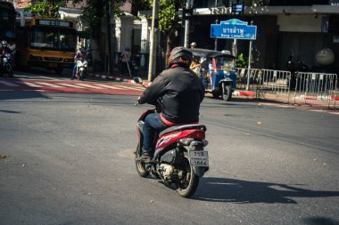 Bangkok, Tayland, 25 Kasım 2024 Tayland 'ın başkenti Bangkok sokaklarında motosikletle gezen insanlar, hayat dolu sokak hayatlarıyla tanınıyorlar..