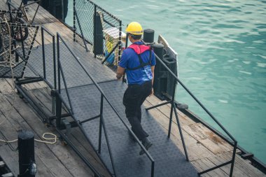 Koh Samui, Tayland, 5 Aralık 2024 Lompray feribot şirketi çalışanları yolcuları yolcu iskelesinde karşılıyor ve gemiyi kalkışa hazırlıyor. Çalışanlar turistlerin güvenliğini sağlıyor.