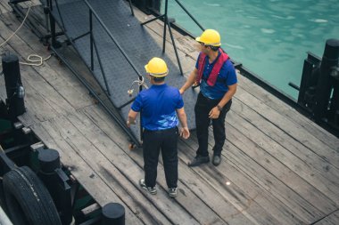 Koh Samui, Tayland, 5 Aralık 2024 Lompray feribot şirketi çalışanları yolcuları yolcu iskelesinde karşılıyor ve gemiyi kalkışa hazırlıyor. Çalışanlar turistlerin güvenliğini sağlıyor.