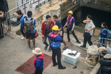 Koh Samui, Tayland, 5 Aralık 2024 Lompray feribot şirketi çalışanları yolcuları yolcu iskelesinde karşılıyor ve gemiyi kalkışa hazırlıyor. Çalışanlar turistlerin güvenliğini sağlıyor.