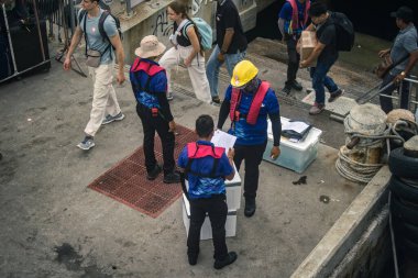 Koh Samui, Tayland, 5 Aralık 2024 Lompray feribot şirketi çalışanları yolcuları yolcu iskelesinde karşılıyor ve gemiyi kalkışa hazırlıyor. Çalışanlar turistlerin güvenliğini sağlıyor.