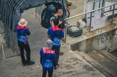 Koh Samui, Tayland, 5 Aralık 2024 Lompray feribot şirketi çalışanları yolcuları yolcu iskelesinde karşılıyor ve gemiyi kalkışa hazırlıyor. Çalışanlar turistlerin güvenliğini sağlıyor.