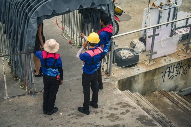 Koh Samui, Tayland, 5 Aralık 2024 Lompray feribot şirketi çalışanları yolcuları yolcu iskelesinde karşılıyor ve gemiyi kalkışa hazırlıyor. Çalışanlar turistlerin güvenliğini sağlıyor.