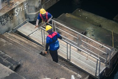 Koh Samui, Tayland, 5 Aralık 2024 Lompray feribot şirketi çalışanları yolcuları yolcu iskelesinde karşılıyor ve gemiyi kalkışa hazırlıyor. Çalışanlar turistlerin güvenliğini sağlıyor.