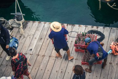 Koh Samui, Tayland, 5 Aralık 2024 Lompray feribot şirketi çalışanları yolcuları yolcu iskelesinde karşılıyor ve gemiyi kalkışa hazırlıyor. Çalışanlar turistlerin güvenliğini sağlıyor.