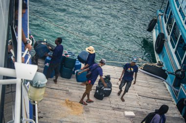 Koh Samui, Tayland, 5 Aralık 2024 Lompray feribot şirketi çalışanları yolcuları yolcu iskelesinde karşılıyor ve gemiyi kalkışa hazırlıyor. Çalışanlar turistlerin güvenliğini sağlıyor.