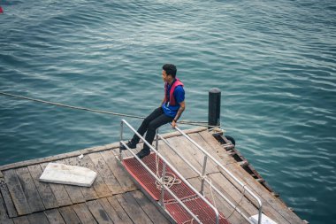 Koh Samui, Tayland, 5 Aralık 2024 Lompray feribot şirketi çalışanları yolcuları yolcu iskelesinde karşılıyor ve gemiyi kalkışa hazırlıyor. Çalışanlar turistlerin güvenliğini sağlıyor.