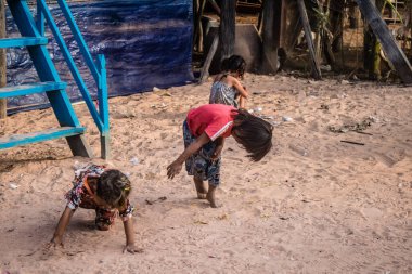 Kampong Phluk, Kamboçya, 15 Ocak 2025. Çocuklar Tonle Sap Gölü 'nde inşa edilen geleneksel yüzen köyde yaşıyorlar. Toplumun hayatta kalması büyük oranda balıkçılık ve turizme bağlı..