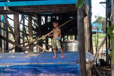 Kampong Phluk, Kamboçya, 15 Ocak 2025. Çocuklar Tonle Sap Gölü 'nde inşa edilen geleneksel yüzen köyde yaşıyorlar. Toplumun hayatta kalması büyük oranda balıkçılık ve turizme bağlı..