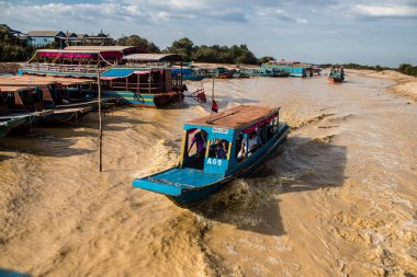 Kampong Phluk, Kamboçya, 15 Ocak 2025. Tekneler Tonle Sap Gölü 'nde inşa edilen geleneksel yüzen balıkçı köyüne açılır. Toplum büyük oranda hayatta kalmak için balıkçılık ve turizme bağımlıdır..