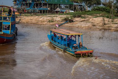 Kampong Phluk, Kamboçya, 15 Ocak 2025. Tekneler Tonle Sap Gölü 'nde inşa edilen geleneksel yüzen balıkçı köyüne açılır. Toplum büyük oranda hayatta kalmak için balıkçılık ve turizme bağımlıdır..