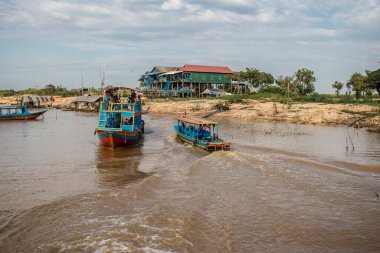 Kampong Phluk, Kamboçya, 15 Ocak 2025. Tekneler Tonle Sap Gölü 'nde inşa edilen geleneksel yüzen balıkçı köyüne açılır. Toplum büyük oranda hayatta kalmak için balıkçılık ve turizme bağımlıdır..
