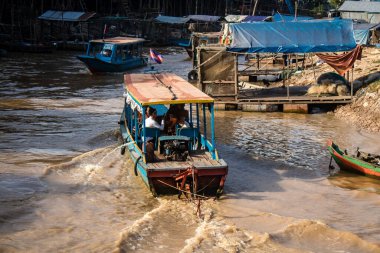 Kampong Phluk, Kamboçya, 15 Ocak 2025. Tekneler Tonle Sap Gölü 'nde inşa edilen geleneksel yüzen balıkçı köyüne açılır. Toplum büyük oranda hayatta kalmak için balıkçılık ve turizme bağımlıdır..