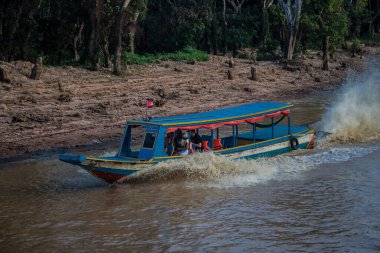 Kampong Phluk, Kamboçya, 15 Ocak 2025. Tekneler Tonle Sap Gölü 'nde inşa edilen geleneksel yüzen balıkçı köyüne açılır. Toplum büyük oranda hayatta kalmak için balıkçılık ve turizme bağımlıdır..