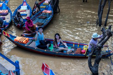 Kampong Phluk, Kamboçya, 15 Ocak 2025. Tekneler Tonle Sap Gölü 'nde inşa edilen geleneksel yüzen balıkçı köyüne açılır. Toplum büyük oranda hayatta kalmak için balıkçılık ve turizme bağımlıdır..