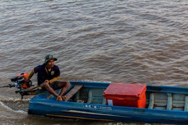 Kampong Phluk, Kamboçya, 15 Ocak 2025. Tekneler Tonle Sap Gölü 'nde inşa edilen geleneksel yüzen balıkçı köyüne açılır. Toplum büyük oranda hayatta kalmak için balıkçılık ve turizme bağımlıdır..