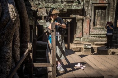 Siem hasadı, Kamboçya, 21 Ocak 2025 'te Angkor Wat' taki Ta Prohm tapınağını ziyaret eden turistler, 1150 ce 'de inşa edilmiş ve antik Khmer başkenti Angkor' da yer alan Hindu-Budist tapınağı kompleksi..