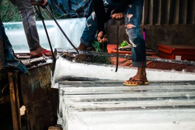 Siem Reap, Kamboçya, 21 Ocak 2025 Buz teslimatçısı bir buz bloğunu bir mağazaya taşıdı. Kamboçya 'da elektrik kesintileri yaygın olduğu için, insanlar bu gıda koruma yöntemini kullanmayı tercih ediyorlar..